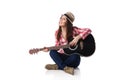 woman musician with guitar sitting on floor.