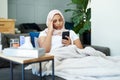 Woman, muslim and phone for headache in home, cold and medicine for illness and treatment for health. Female person Royalty Free Stock Photo