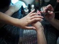 Woman in a nail salon receiving a manicure by a beautician with nail file woman