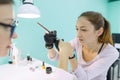 Woman in nail salon receiving manicure by manicurist, closeup manicure process. Nail and hand care in beauty salon.