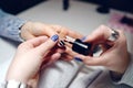 Woman in a nail salon receiving a manicure nail gel polish by a professional beautician