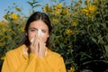 Woman with napkin fighting blossom allergie outdoor. Attractive girl outdoor with tissue having allergy. Young female is