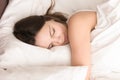 Woman napping while hugging soft pillow in bed