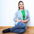 Woman natural portrait. Smiling girl seat on a floor. White bac