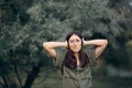 Woman in Nature Covering her Ears Hearing a Loud Noise