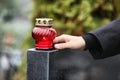 Woman near black granite tombstone with candle, closeup. Funeral ceremony Royalty Free Stock Photo