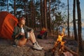 Woman near campfire is putting mug aside Royalty Free Stock Photo