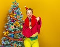 Woman near Christmas tree with microphone pointing at camera Royalty Free Stock Photo