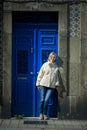 A woman near the front door of an tipical portugal apartment building.