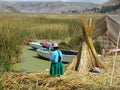 Woman near her family boats at one of the Uros' islands - Lake Titicaca