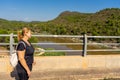 A woman near the railings of a dam of Algar del Palancia on a sunny day