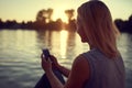 Woman near water with cellphone Royalty Free Stock Photo