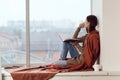 woman near the window with a plaid cup of hot drink rest Royalty Free Stock Photo