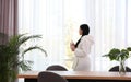 Woman near window in room decorated with plants. Home design Royalty Free Stock Photo