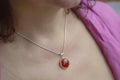 Woman neckline wearing carneol mineral stone pendant on silver chain