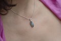 Woman neckline wearing labradorite mineral stone pendant on silver chain