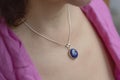 Woman neckline wearing lapis lazuli mineral stone pendant on silver chain