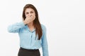 Woman needs keep mouth shut. Portrait of casual european female brunette in blue blouse, covering mouth with palm and