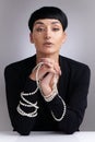 A woman needs ropes and ropes of pearls. Studio portrait of a beautiful young woman with pearls on her face posing Royalty Free Stock Photo