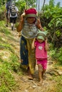 A woman of Nepal and her young son carry a sack tied to their forehead by a strap. Royalty Free Stock Photo