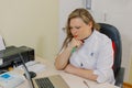 Woman neurologist pondered at the computer in the office of the clinic.