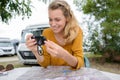Woman next to campervan and checking photo on camera Royalty Free Stock Photo