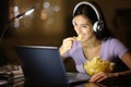 Woman in the night eating potato chips watching media Royalty Free Stock Photo
