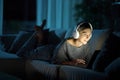 Woman in the night at home using personal computer and headphone Royalty Free Stock Photo