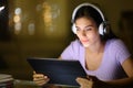 Woman in the night using headphone and tablet Royalty Free Stock Photo