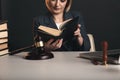 Woman with notary books in office. Wooden gavel with libra and laptop concept.