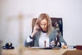 Woman notary public, attorney sits at a wooden desk in her notary office talking on the phone. Royalty Free Stock Photo