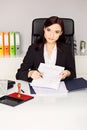 Woman notary public holding pen and pointing at signature place