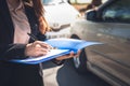 Woman notify insurance agents is writing an accident car crash report