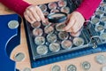 Woman-numismatist considers coins from the album for coins in capsules