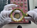 Woman numismatist examining coin with magnifier Royalty Free Stock Photo