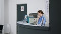 Woman nurse answering landline phone call at reception desk Royalty Free Stock Photo