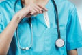 Woman nurse or doctor close up while she is putting a thermometer inside her chest pocket