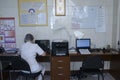 Woman nurse sitting in a nurses station and writing in a paper, maternity hospital Royalty Free Stock Photo