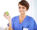 Woman, nurse and smile portrait with apple in medical office, nutrition and healthy food choice, professional nursing