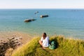 A woman observes the remains of the Mulberry harbour in Normandy Royalty Free Stock Photo