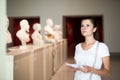 Woman observing sculptures exposition in art museum Royalty Free Stock Photo