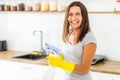 Woman with obsessive compulsive disorder cleaning kitchen with detergents, but everything is clean anyway.