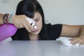 Woman with obsessive compulsive disorder cleaning table with detergents. OCD concept