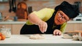 Woman is occupied with dough preparation