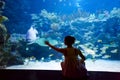 Woman in the oceanarium near alligator gar fish Royalty Free Stock Photo