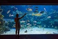 Woman in the oceanarium near alligator gar fish Royalty Free Stock Photo