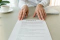 Woman offering contract for signing or reading terms, close up