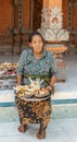 Woman with offerings at clan compound, Dusun Ambengan, Bali Indonesia