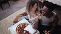 Woman offers pizza to man, but eat slice by herself. Multiracial couple having fun during the meal with fast food.