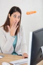 woman at office desk looks in surprise at dangling carrot